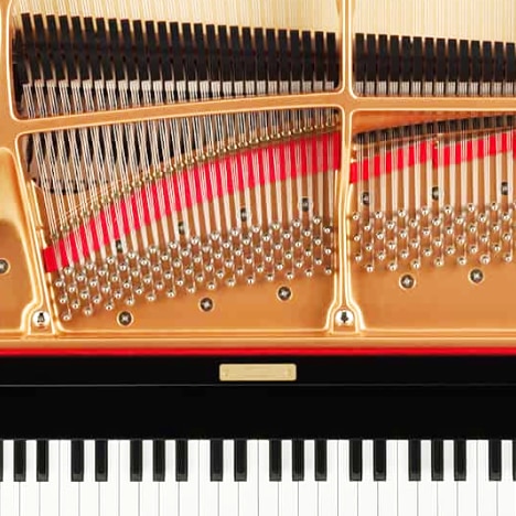 Close-up of the keyboard, strings and hammers of a grand piano, seen from above