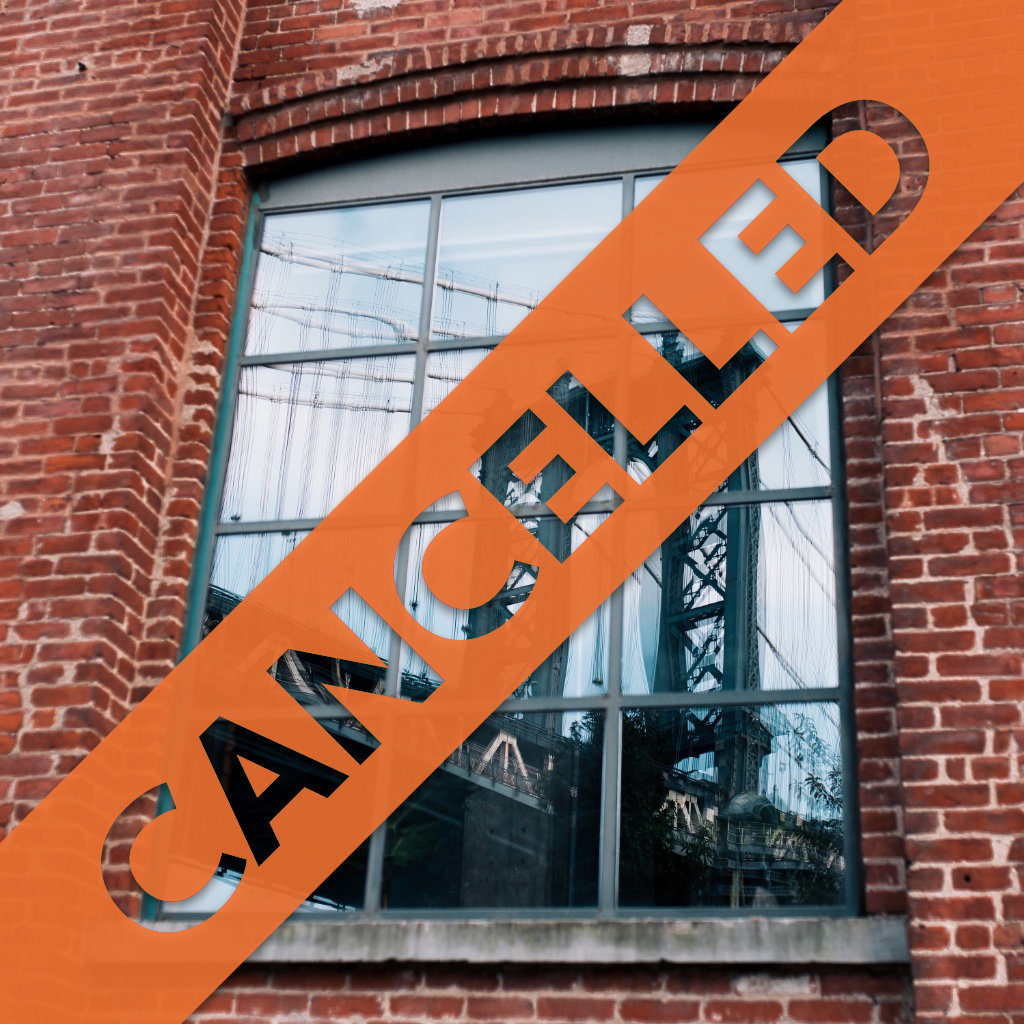 Reflection of the Manhattan Bridge in a window emblazoned with the text “CANCELLED”