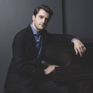 Portrait of pianist David Kaplan seated at the piano